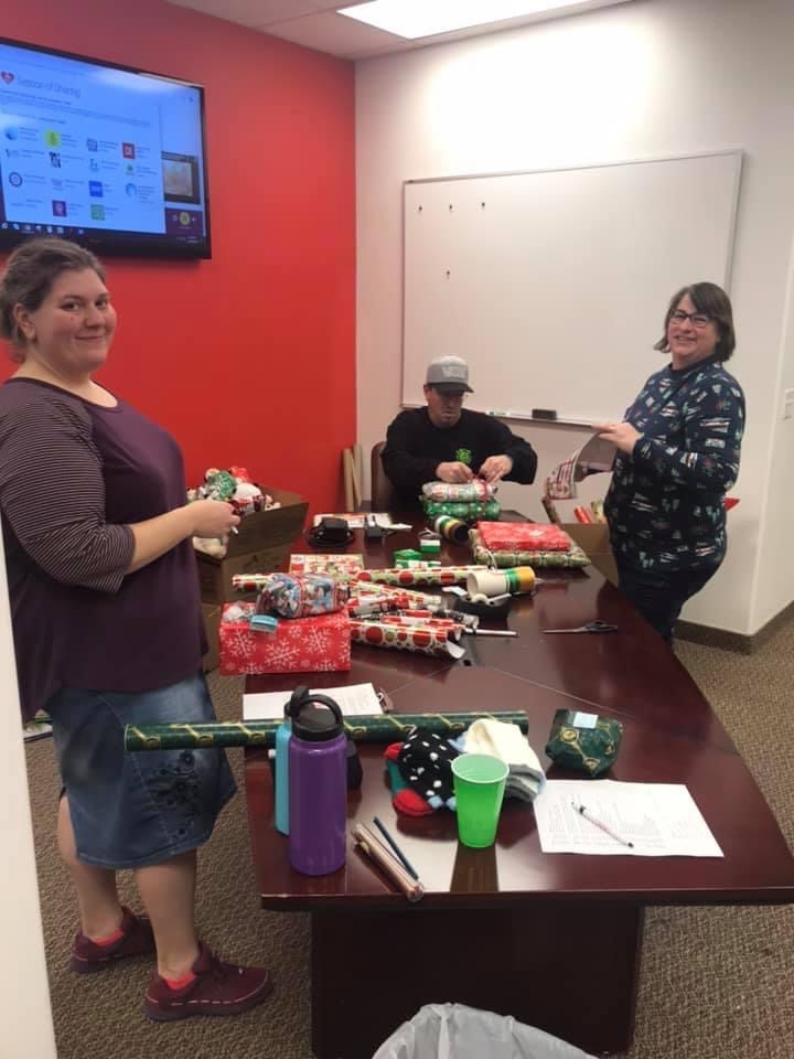 Volunteers wrapping gifts in an office