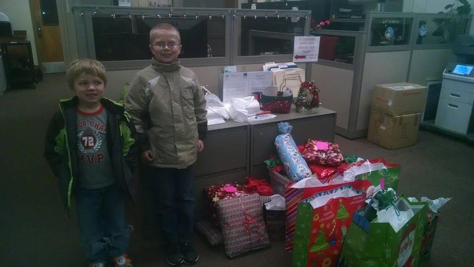 Two young boys with a pile of gift bags for drop-off