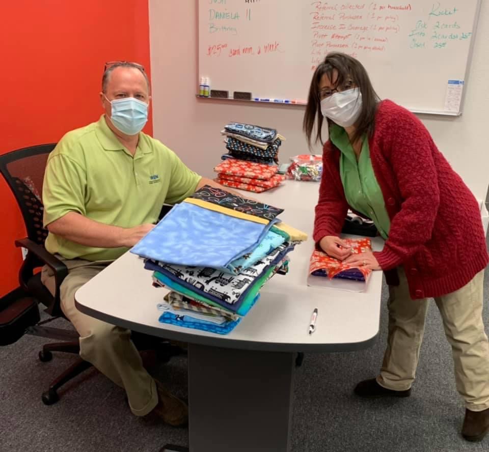 Male and female volunteer wrapping gifts in an office