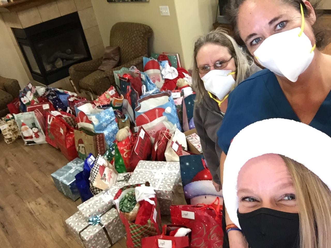 Volunteers and facility workers showing off all of the donations to a facility.