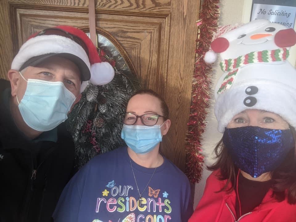 Three volunteers in face masks posing before making deliveries