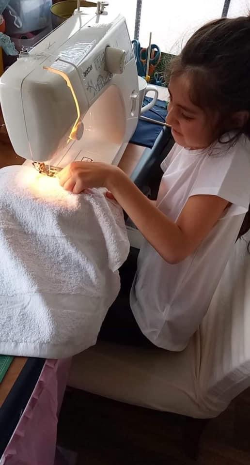 Young girl hemming a blanket