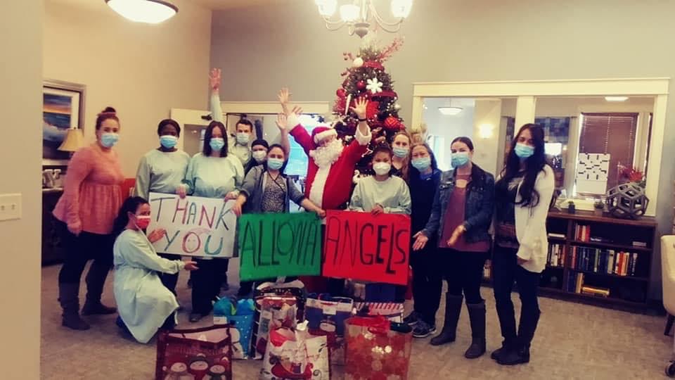 Workers at facility holding up signs thanking Allonas Angels for their gift contributions